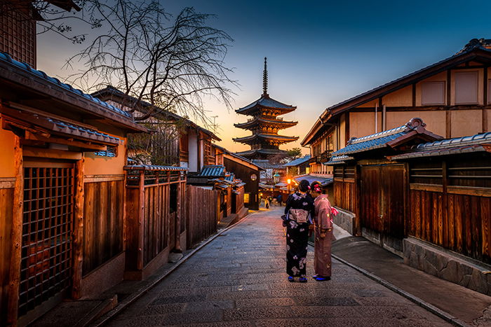 A portrait of two people standing by an impressive temple in Kyoto at sunset - pictures of Japan