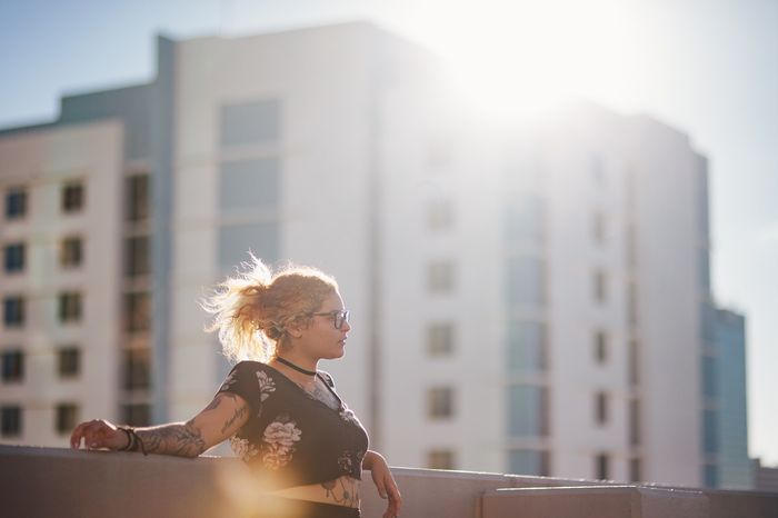 photo of a girl on top of a building with lens flare