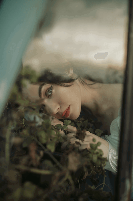 an image of a woman resting her head on the forest floor