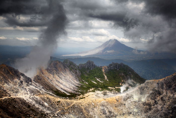 Two volcanos taken from Mount Sibayak, and looks towards Mount Sinabung. Sinabung was active at the time this photo was taken. You can see the ash on the left flank of the volcano.