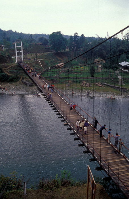 Aerial view of a group of people crossing a wooden bridge 