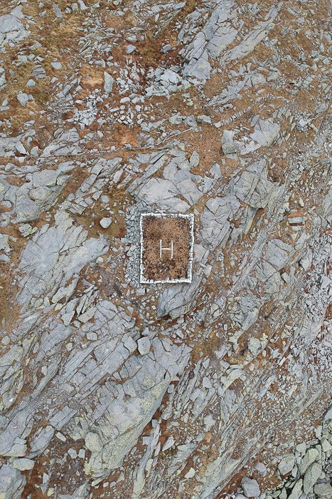 A stunning abstract aerial landscape photography shot of a helicopter landing area on rocky terrain