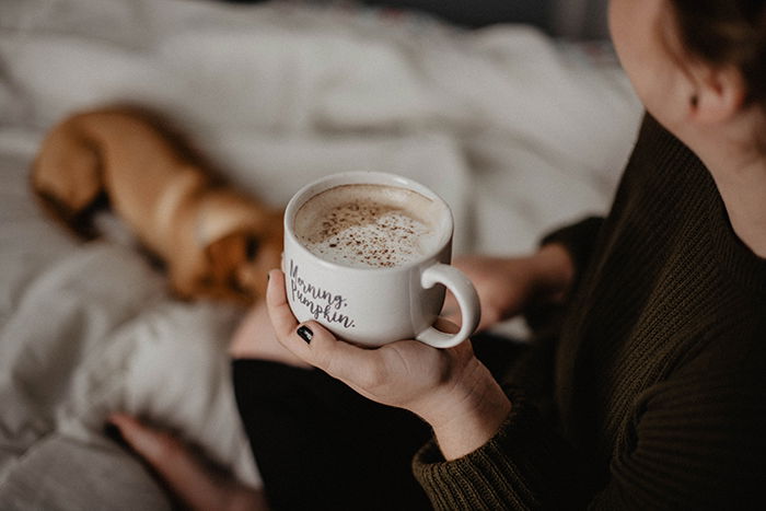 A cosy indoor portrait of a female model and a dog - autumn photography tips 