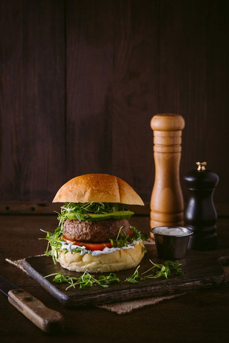 A delicious burger photo setup on rustic board and background