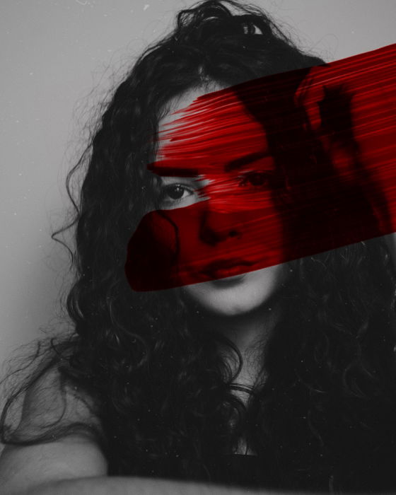 Black and white portrait of a woman edited with a streak of red paint 