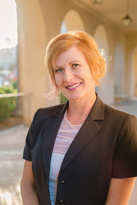 A corporate headshot of a female posing in front of architectural buildings - headshot background ideas