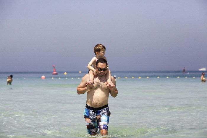 A father and son walking in the ocean 