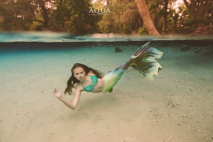 A magical underwater mermaid photoshoot featuring a female model with mermaid tail swimming underwater