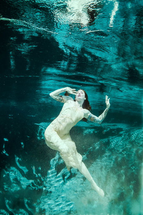 A magical underwater mermaid photoshoot featuring a female model posing underwater