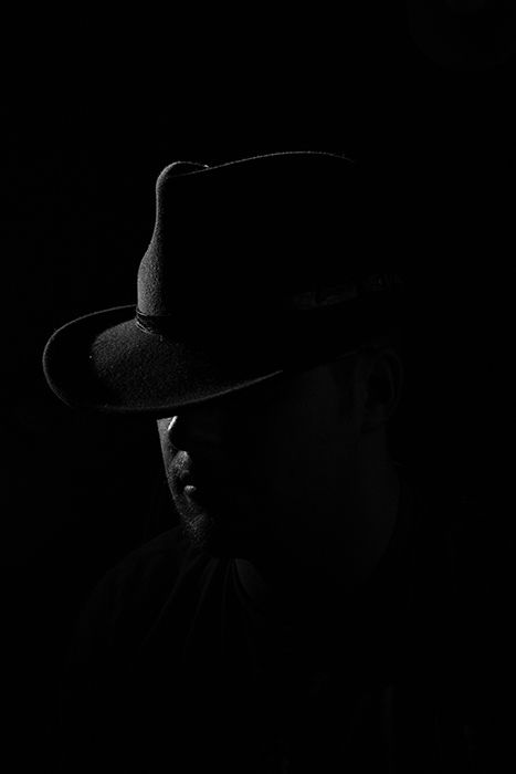 Film noir photography portrait of a male model wearing a cowboy hat