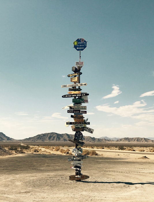 Many road signs in a deserted landscape 