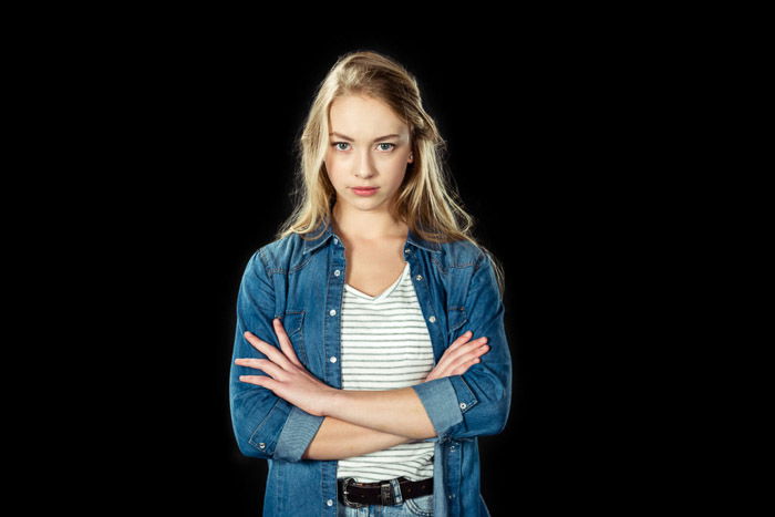 A school portrait of a female student posing against black background 