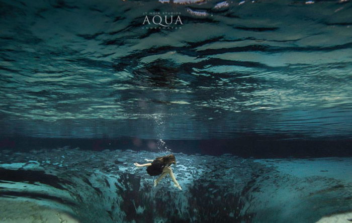 Dreamy underwater portrait of a female model swimming 