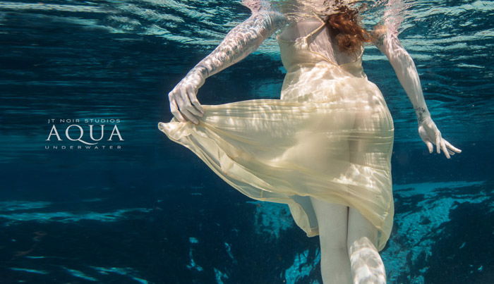 Dreamy underwater portrait of a female model swimming 