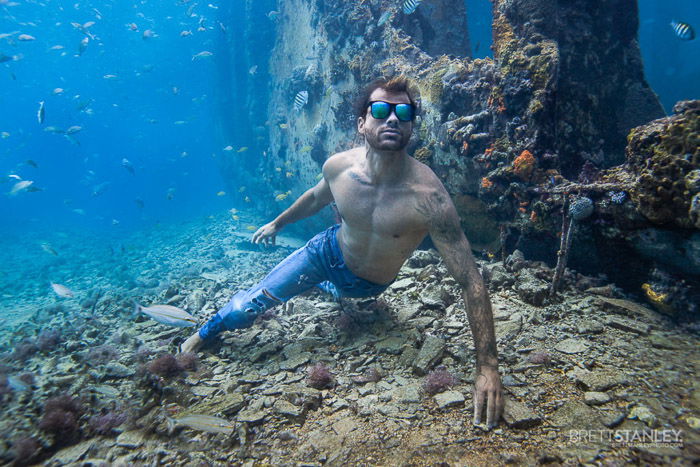 Atmospheric underwater ocean picture of a male model swimming under the water