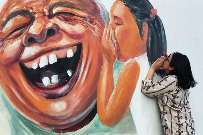 Urban portrait of a female model posing by wall graffiti 