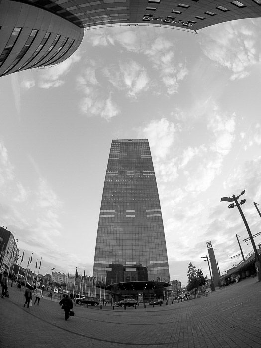 A tall skyscraper shot in black and white with a fisheye lens 