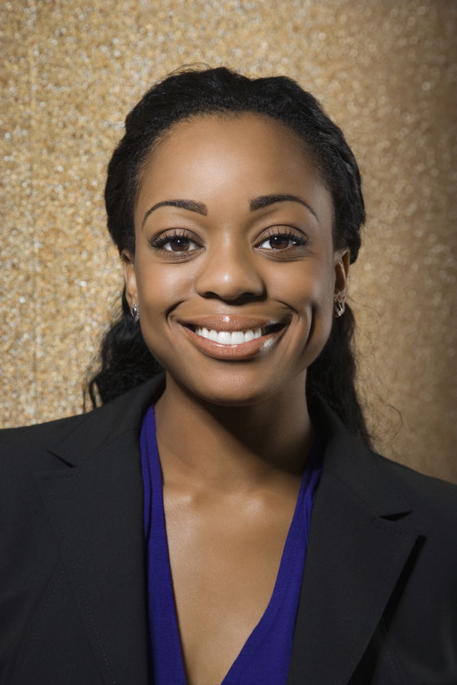 Smiling African American woman with brown hair wearing a dark suit.