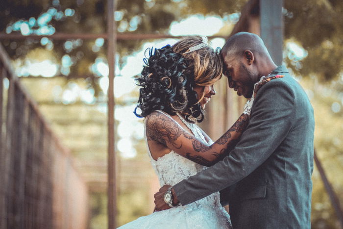 Artistic portrait of a newlywed couple embracing outdoors - fine art wedding photography 