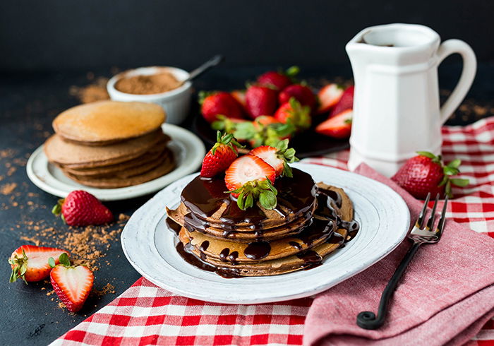 A stunning still life of a plate of chocolate covered pancakes shot using ring light photography