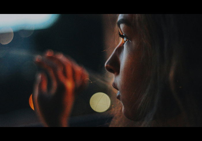 A dark profile portrait of a moody female model looking out a window at night - examples of dark portraits