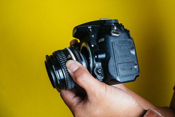 A Nikon DSLR lens on yellow background 