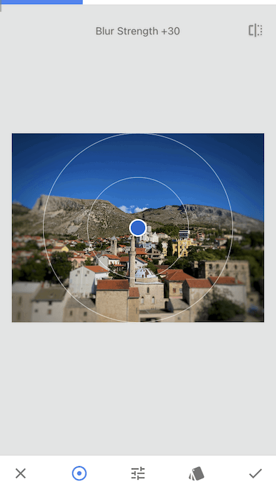 City landscape image being edited in Snapseed app using Lens Blur tool for a tilt-shift effect