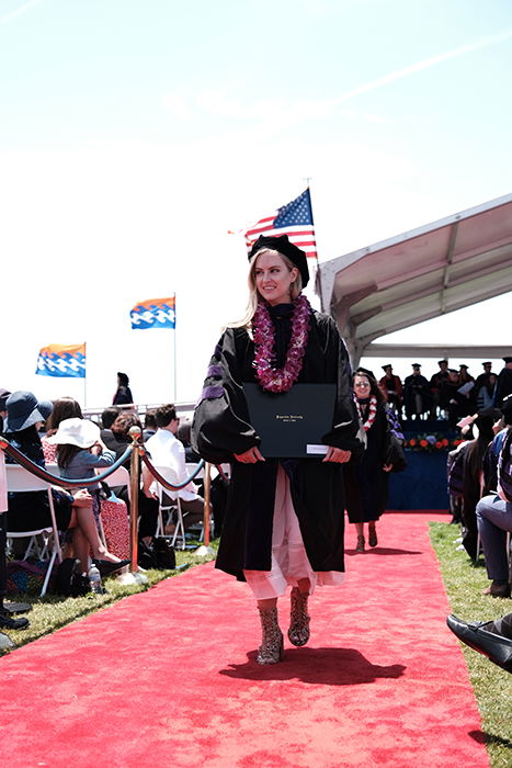 Beautiful candid graduation portrait of a female student walking outdoors