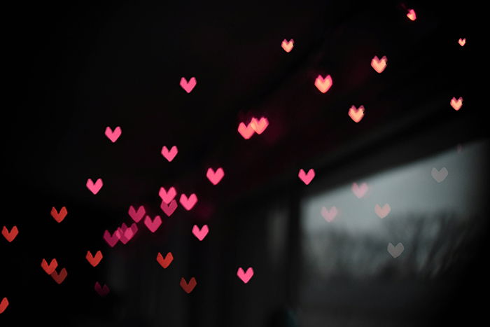 Red and pink heart bokeh lights on a dark background