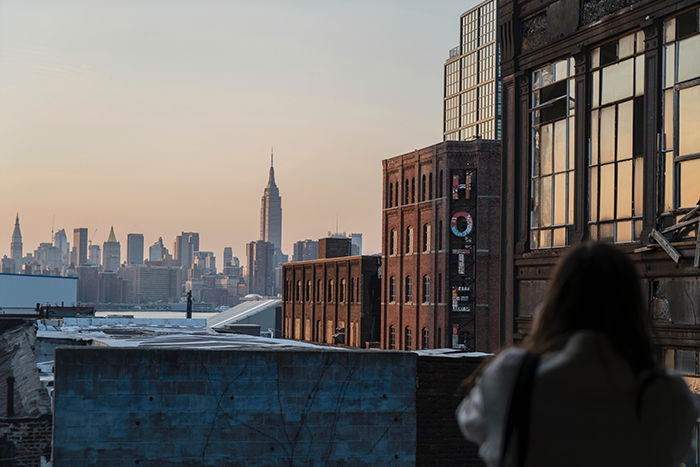 A blonde model posing on a rooftop gazing out at a sprawling cityscape - lifestyle portraits