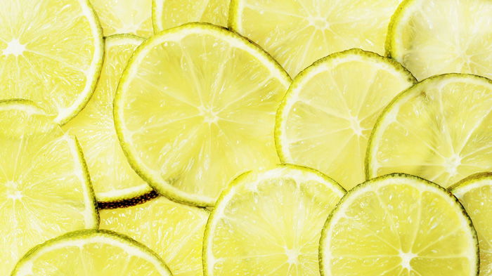 A close up photo of sliced limes using greeny yellow monochromatic color scheme