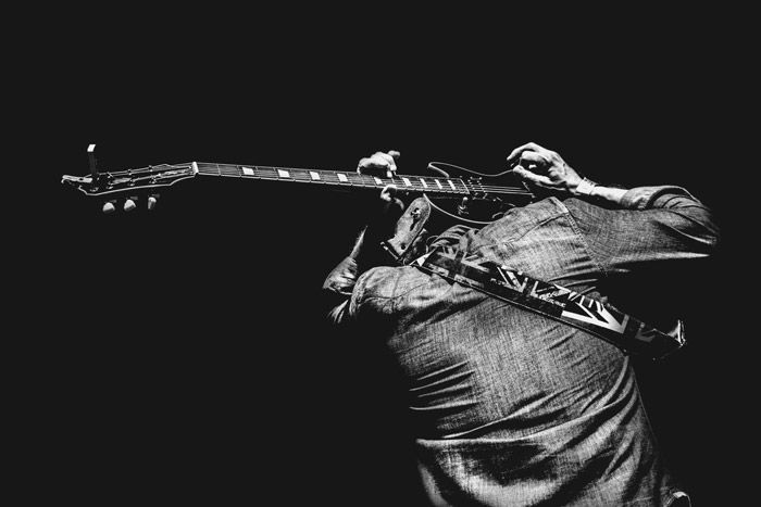 Atmospheric monotone portrait of a performer onstage at a festival