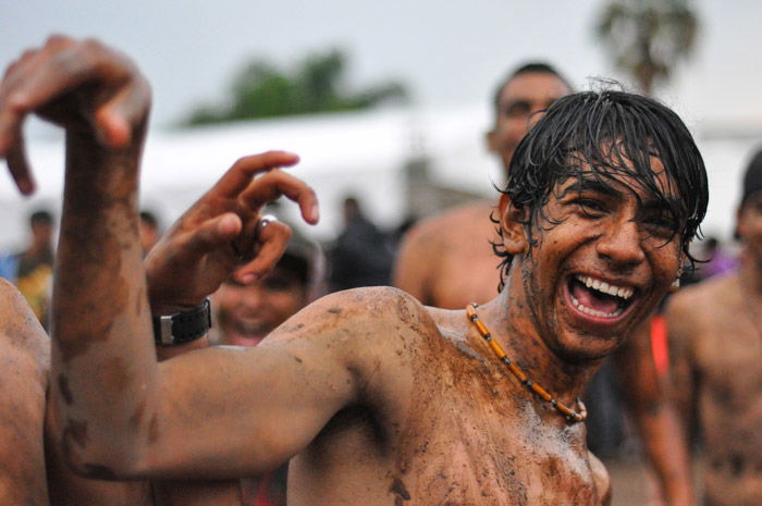 A portrait of a mud covered pundit at a music festival