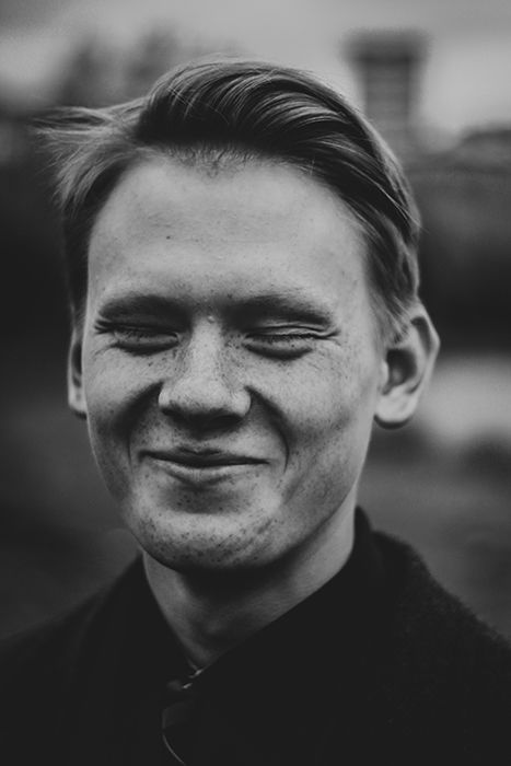 A black and white portrait of a man smiling natural - how to smile for pictures