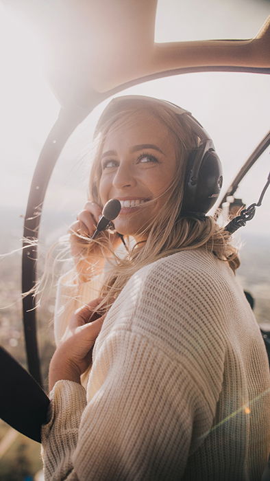 A joyful photo of a blonde woman in an aircraft smiling naturally