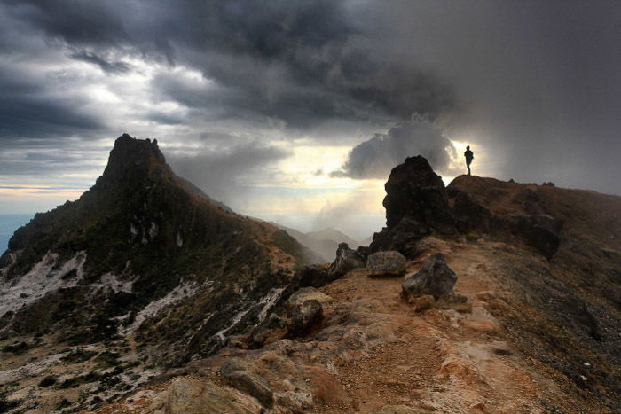 A hiker admires the dawn scenery on the currently dormant volcano of Sibayak in Indonesia. -volcano and lava photography