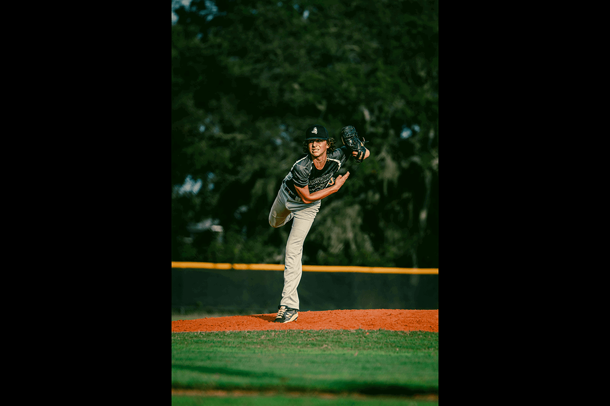 A pitcher on a mound that just threw a ball as an example for baseball photography