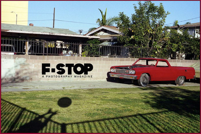 An advertisement with a red car in a driveway for F-Stop, one of the top magazines looking for photo submissions