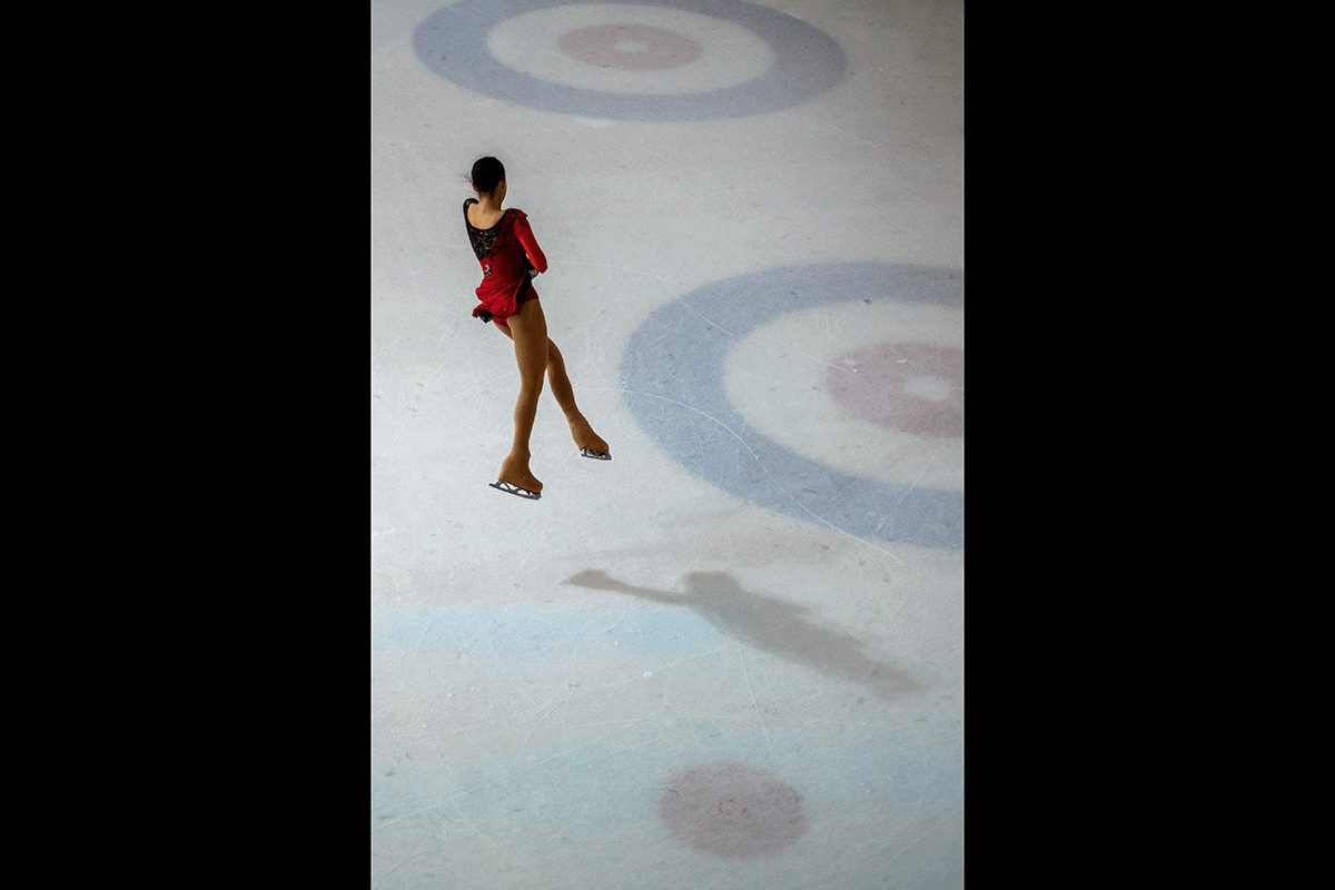 A skater mid-jump shot from a high-angle as an example of figure skating photography