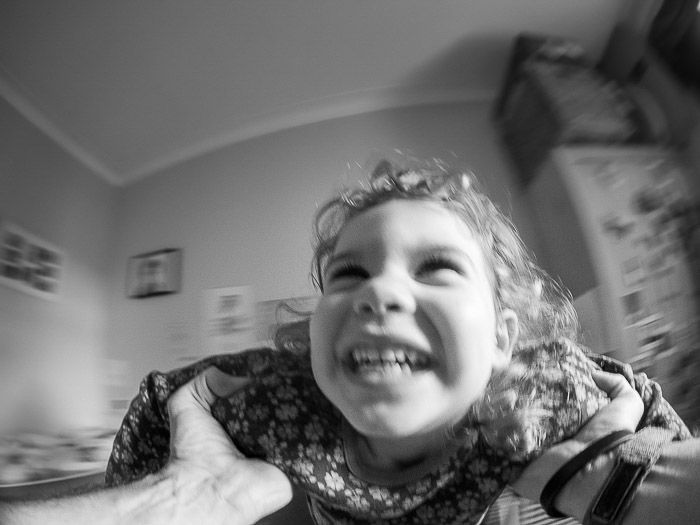 Black and white portrait of a smiling child shot with a fisheye lens