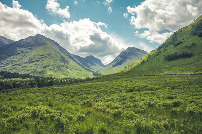 a luscious green mountainous landscape under a cloudy sky - stunning landscape photos 