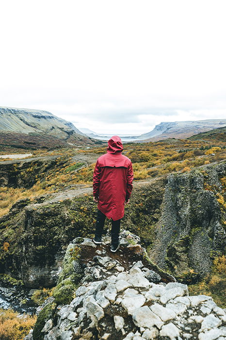 a photographer standing on a rocky in a mountainous landscape - Iceland photography spots