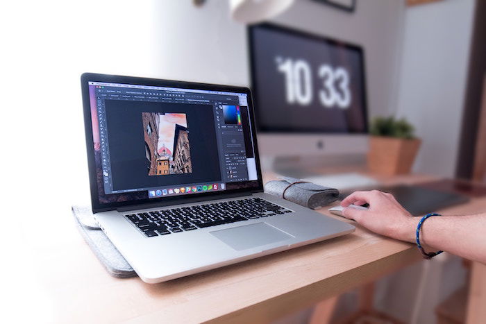 A person using Lightroom on a laptop in a home office