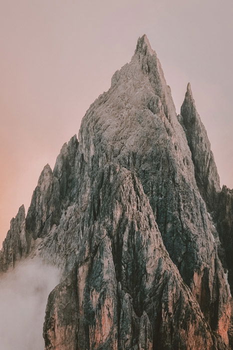 a rocky mountaintop against a soft pink sky - stunning landscape photos 