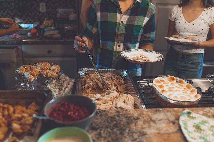 Candid thanksgiving picture of people serving themselves food