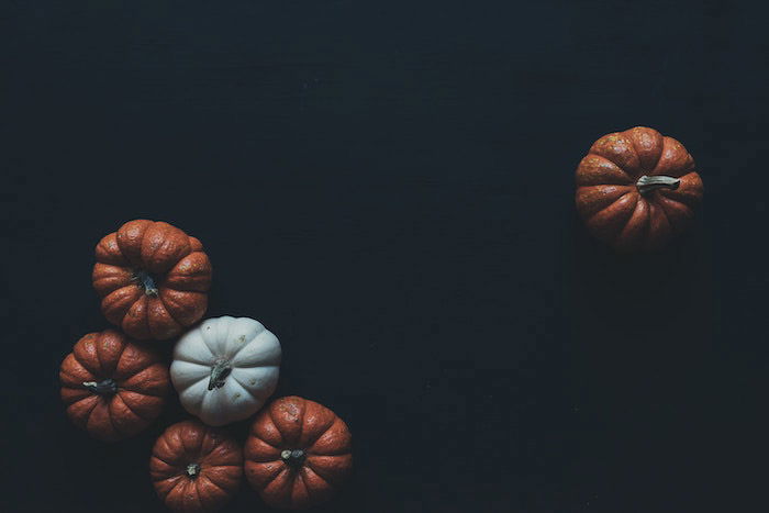 A thanksgiving photography flatlay featuring pumpkins on a black background