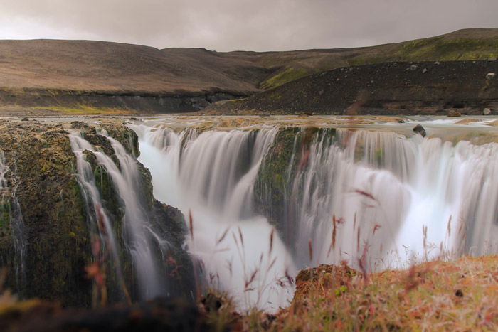 a dreamy mountainous landscape over a waterfall - stunning landscape photos 