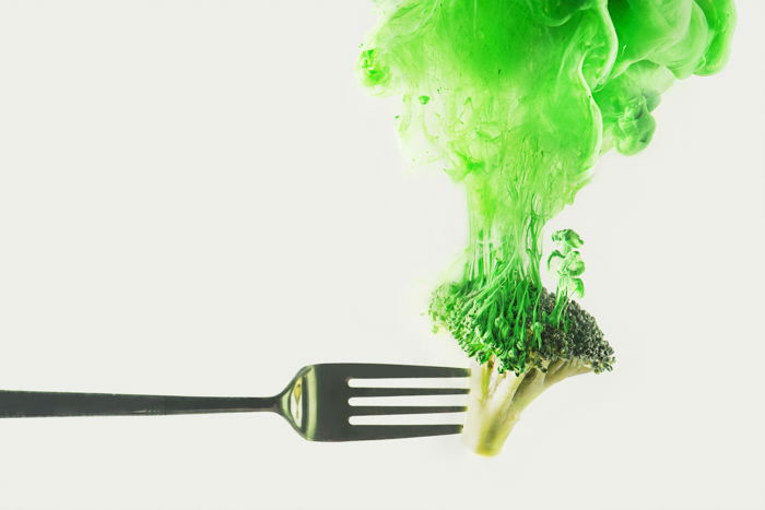 A fork of broccoli with green cloud using colorful paint in water photography technique