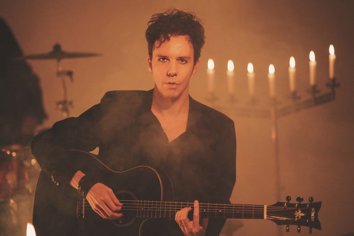 Atmospheric portrait of a male musician playing guitar 