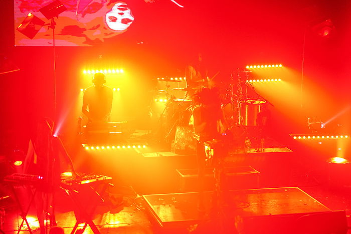 Atmospheric concert photo of a stage lighted with electric red and yellow light 